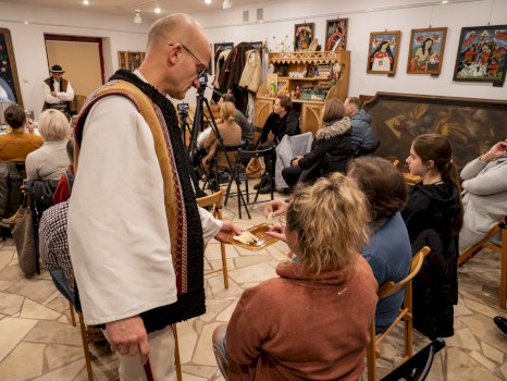 Na tej fotografii widzimy dyrektora Muzeum imienia Władysława Orkana ubranego w strój góralski, który częstuje świeżo zrobionym serem uczestników szkolenia.