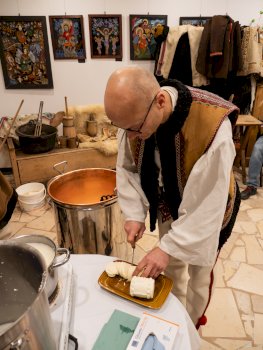 Na tym zdjęciu widać dyrektora Muzeum imienia Władysława Orkana ubranego w strój góralski, który kroi sery do degustacji przez uczestników szkolenia.